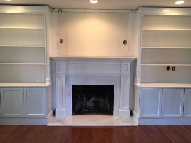 Classic and Simplistic stone fireplace with white shelving on both sides